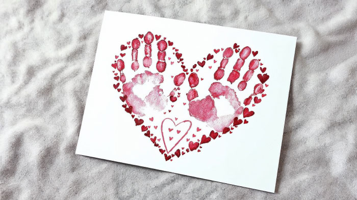 A heartfelt card created by tracing both hands and folding them into a heart shape, symbolizing love and warmth.