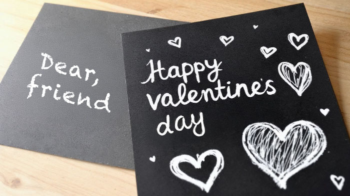 A black cardstock card featuring white chalk-like doodles and messages for a vintage, handwritten aesthetic.