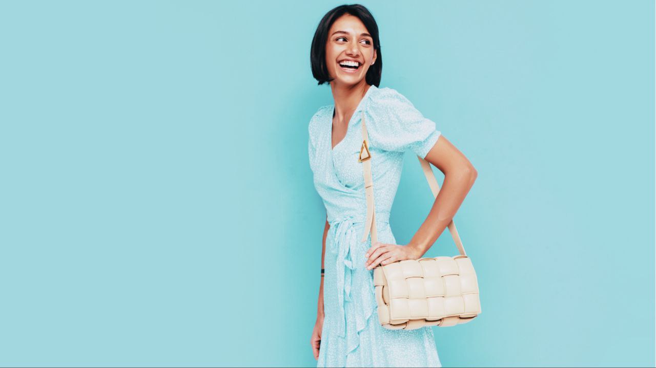 A photo of a woman in a blue dress wearing an off-white sling bag